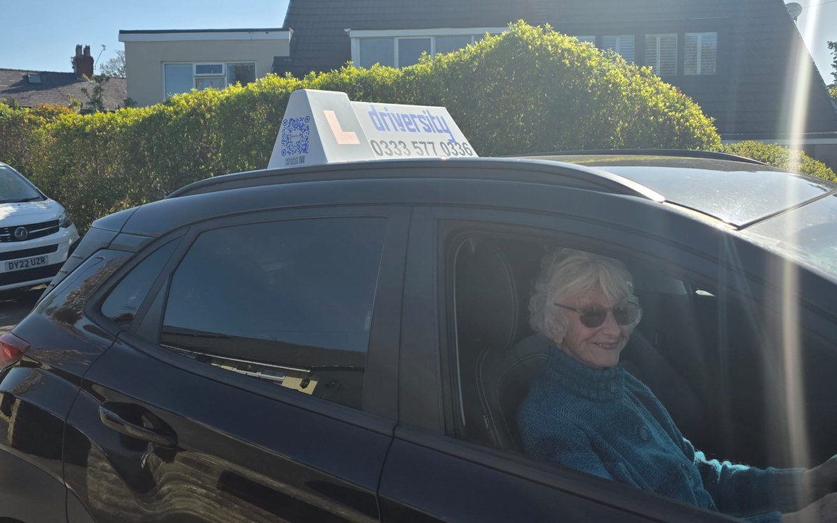 Driversity pupil smiling at the wheel of a Driversity car during a refresher lesson